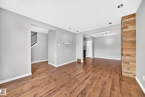 Spacious interior featuring wood-finish flooring, recessed ceiling lights, and light gray painted walls - 32 Mcleod Place, Edmonton, AB 