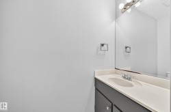 Bathroom vanity with an integrated sink, cream-toned countertop, and dark cabinetry - 