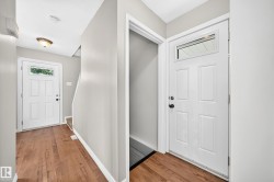 Entryway featuring wood-finish flooring, light gray wall paint, and white trim - 