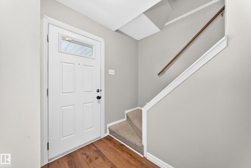 Entryway featuring wood-finish flooring and a white paneled door with an upper glass insert - 32 Mcleod Place, Edmonton, AB 