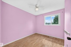 Room featuring wood-finish flooring, a ceiling fan with integrated lighting, and a window providing natural illumination - 