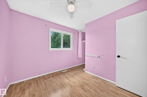 Interior room featuring wood-finish flooring, a white trim baseboard, and pink walls - 32 Mcleod Place, Edmonton, AB 