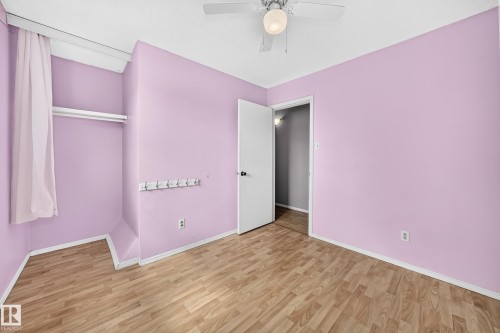 Room with wood-finish flooring, a ceiling fan with integrated lighting, and a built-in closet with a hanging rod - 32 Mcleod Place, Edmonton, AB 