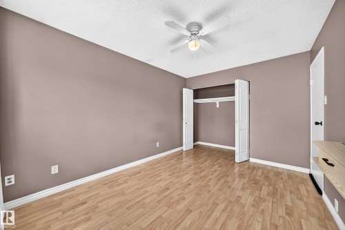 Room featuring wood-finish flooring, neutral wall paint, and a textured white ceiling - 32 Mcleod Place, Edmonton, AB 