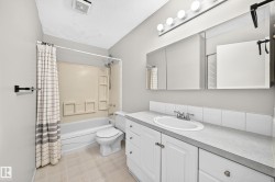 Bathroom featuring a white vanity with integrated sink, a three-section mirrored medicine cabinet, and a five-bulb light fixture - 