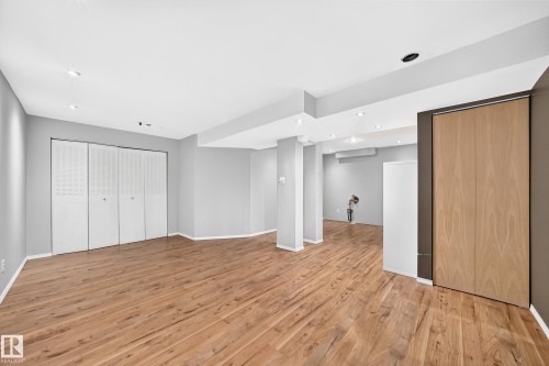 Expansive interior space featuring wood-finish flooring, recessed lighting, and light grey walls - 32 Mcleod Place, Edmonton, AB 
