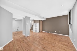 Spacious room featuring wood-finish flooring, recessed lighting, and a neutral color palette - 