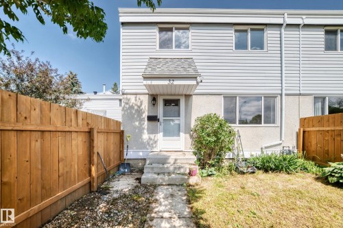 Two-story townhouse exterior with light-colored siding and a concrete foundation - 32 Mcleod Place, Edmonton, AB 