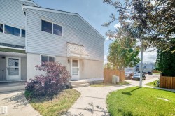 Two-story townhome with light blue siding and a white stucco base - 