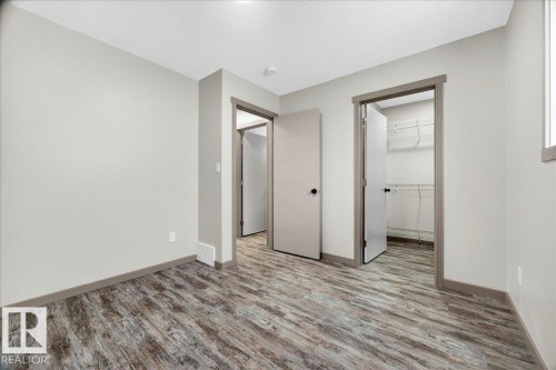 Room featuring wood-finish flooring and light gray walls - 1 Whitetail Way, Mundare, AB 