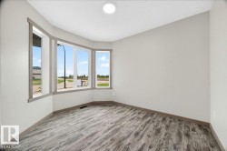 Bay window with multiple panes, wood-finish flooring, light neutral wall paint, white ceiling, and a flush mount ceiling light - 