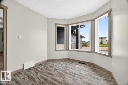 Bay window arrangement with white trim and grey accent framing - 1 Whitetail Way, Mundare, AB 