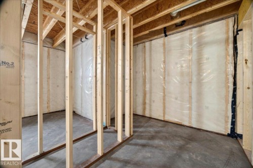 Unfinished lower level with wood framing, exposed ceiling joists, concrete flooring, and insulated walls - 1 Whitetail Way, Mundare, AB 