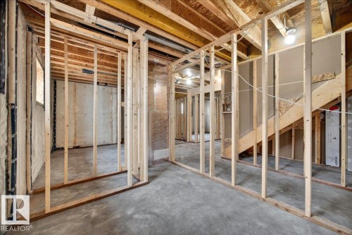 Unfinished basement featuring exposed wood framing, concrete flooring, and partial wall insulation - 1 Whitetail Way, Mundare, AB 