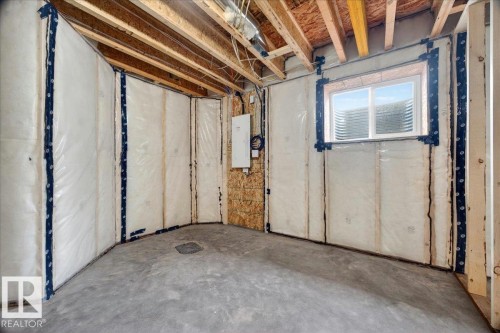 Unfinished basement space featuring exposed wood joists and concrete flooring - 1 Whitetail Way, Mundare, AB 