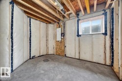 Unfinished basement space featuring exposed wood joists and concrete flooring - 