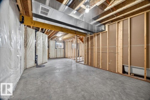 Unfinished basement space featuring exposed wooden joists, concrete flooring, perimeter insulation, and structural framing - 1 Whitetail Way, Mundare, AB 