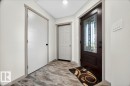 Entryway featuring a dark wood-finish door with decorative glass, wood-finish flooring, and light-toned walls - 1 Whitetail Way, Mundare, AB 
