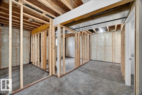 Unfinished basement space featuring exposed wooden framing, concrete flooring, and visible insulation - 1 Whitetail Way, Mundare, AB 
