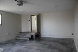 Spacious garage with painted walls, concrete flooring, and an elevated entry platform with steps - 