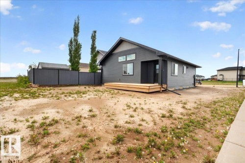 Contemporary exterior with dark gray siding and a light wood-tone deck - 1 Whitetail Way, Mundare, AB 