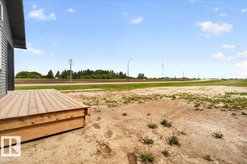 Side patio deck with natural wood planks and a gravel ground perimeter - 1 Whitetail Way, Mundare, AB 