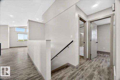 Upper-level hallway featuring wood-finish flooring, recessed lighting, and modern interior doors - 1 Whitetail Way, Mundare, AB 