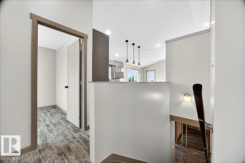 Hallway with wood-finish flooring, white walls, and contrasting trim - 1 Whitetail Way, Mundare, AB 