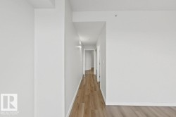 Hallway featuring wood-finish flooring, white walls, and recessed lighting - 