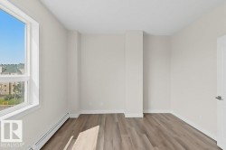 Light-filled interior featuring wood-finish flooring, white baseboards, and a large window with white framing - 