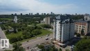 High-rise residential building featuring multiple balconies, a distinctive peaked roofline, and a light-colored exterior - 505 9707 105 Street, Edmonton, AB 