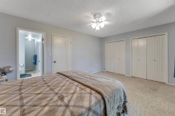 Carpeted room with light gray walls, featuring two sets of bi-fold closet doors and an additional solid white door - 