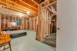 Framed basement area with exposed wood joists and subflooring - 