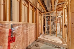 Framed basement interior with visible insulation and a pre-installed shower base - 