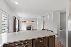 Kitchen island with a light-toned countertop, integrated dishwasher, and under-counter cabinetry - 