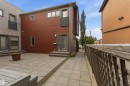 Spacious rear patio featuring paver stones and a composite deck platform - 1 14315 Stony Plain, Edmonton, AB 