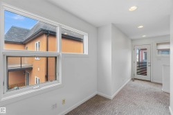 Bright interior space featuring a large multiple-pane window, recessed ceiling lighting, a door with horizontal louvered glass, and patterned carpeting - 
