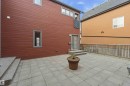 Expansive stone paver patio featuring a sliding glass door entry and two-step concrete stairs - 1 14315 Stony Plain, Edmonton, AB 
