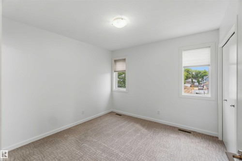 Bright room with neutral wall finishes and patterned carpeting - 1 14315 Stony Plain, Edmonton, AB 