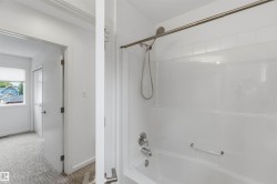 White tub and shower combination with a brushed nickel showerhead and faucet - 