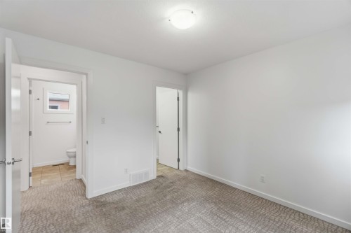 Room featuring patterned carpeting, white walls, and a flush-mount ceiling light - 1 14315 Stony Plain, Edmonton, AB 