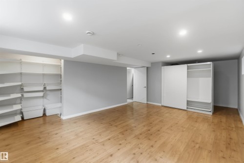 Spacious room with wood-finish flooring, recessed lighting, and light gray wall paint - 1 14315 Stony Plain, Edmonton, AB 