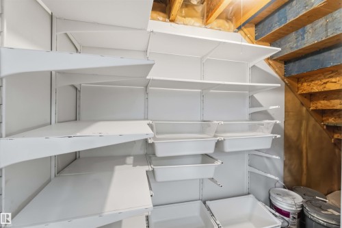 Extensive white shelving system with integrated storage bins, set within an exposed wood-beam utility space - 1 14315 Stony Plain, Edmonton, AB 