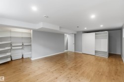 Spacious room with wood-finish flooring, recessed lighting, and light gray wall paint - 