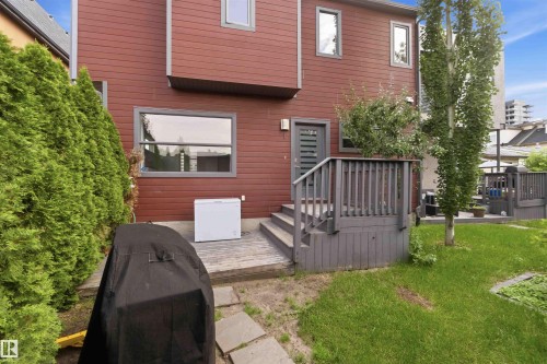 Red horizontal siding exterior with a grey deck and matching railings - 1 14315 Stony Plain, Edmonton, AB 