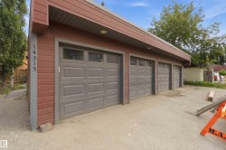 Detached garage structure featuring red siding and a gray trim - 