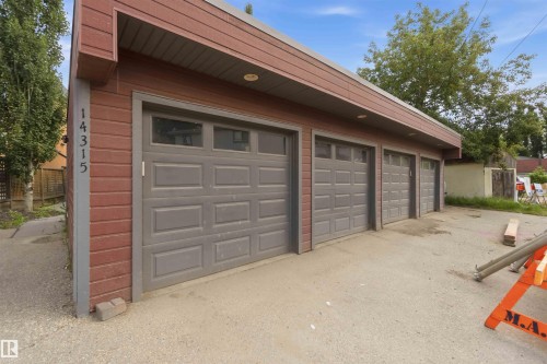 Detached garage structure featuring red siding and a gray trim - 1 14315 Stony Plain, Edmonton, AB 