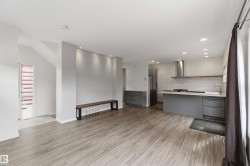 Open-concept living space featuring wood-finish flooring, recessed lighting, and a modern kitchen - 