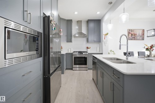 Modern kitchen featuring gray cabinetry and stainless steel appliances - 2508 193 Street, Edmonton, AB 