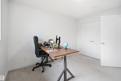 Bright room featuring light-colored carpeting, white baseboards, and a window providing natural illumination - 2508 193 Street, Edmonton, AB 